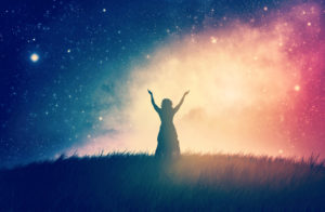 Energiearbeit A woman in a field praises at night